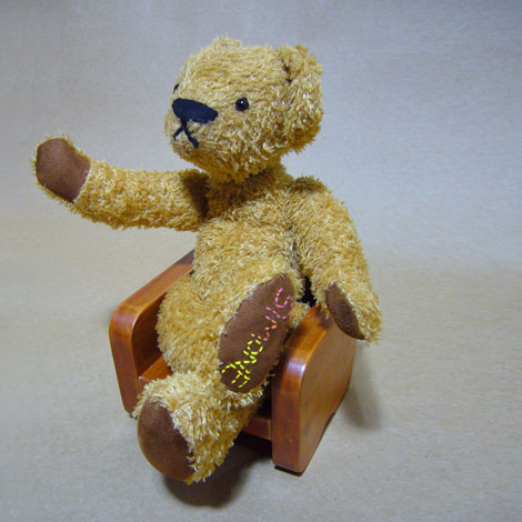teddy in chair waving