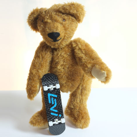 Levi standing up with his board resrting verticvally against him, showing the carbon underside of his board