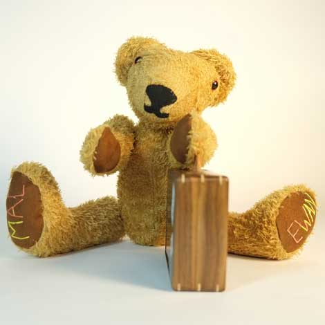 MacEwan sitting legs apart with suitcase in the middle