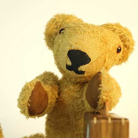 Close up of MacEwan sitting legs apart with suitcase in the middle